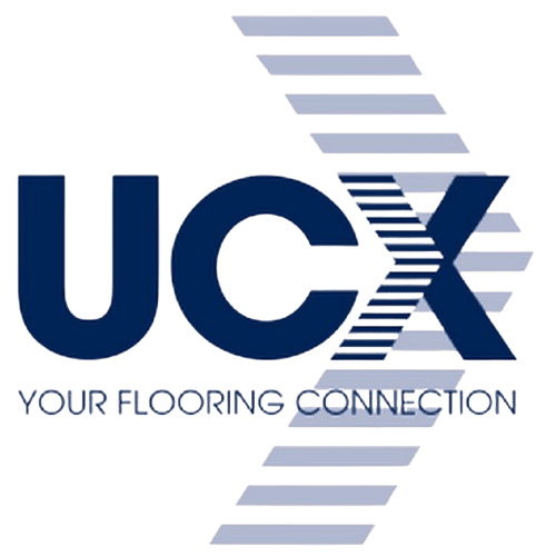 Logo for UCX featuring the letters "UCX" in a bold navy blue font. A series of light blue-grey diagonal stripes create a motion effect behind the letter "X." Below the main text, the phrase "YOUR FLOORING CONNECTION" is written in a small, navy blue sans-serif font.